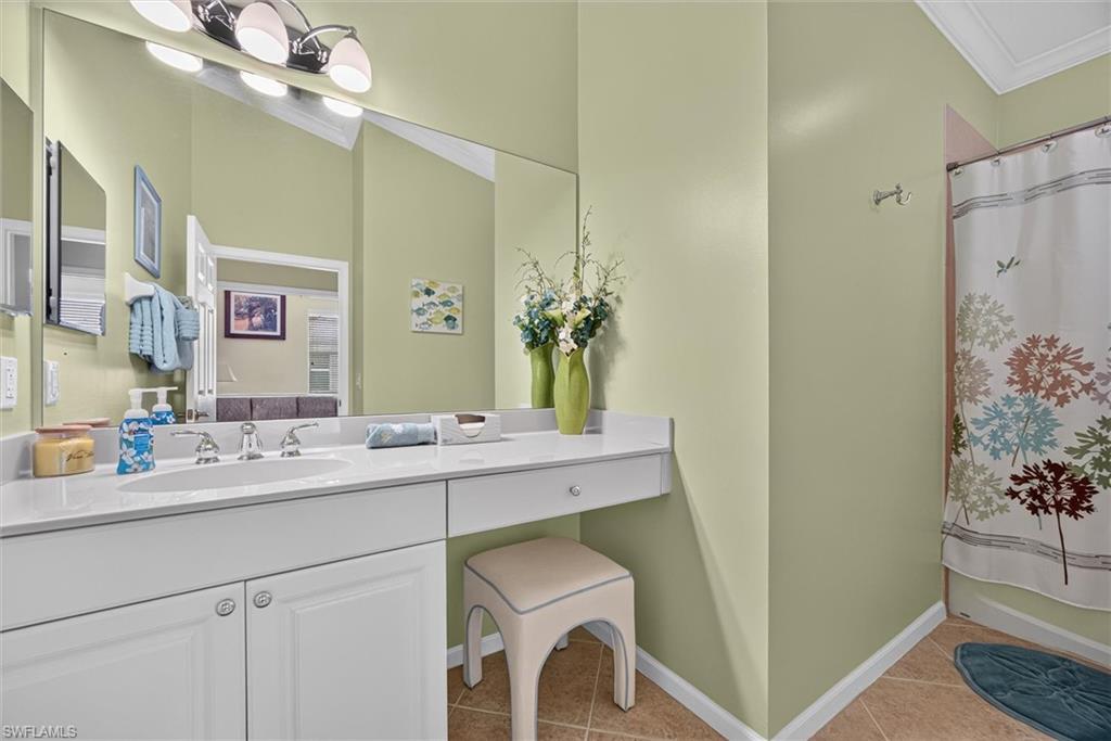 Double vanity featuring a light-toned countertop, integrated sinks, and white cabinetry