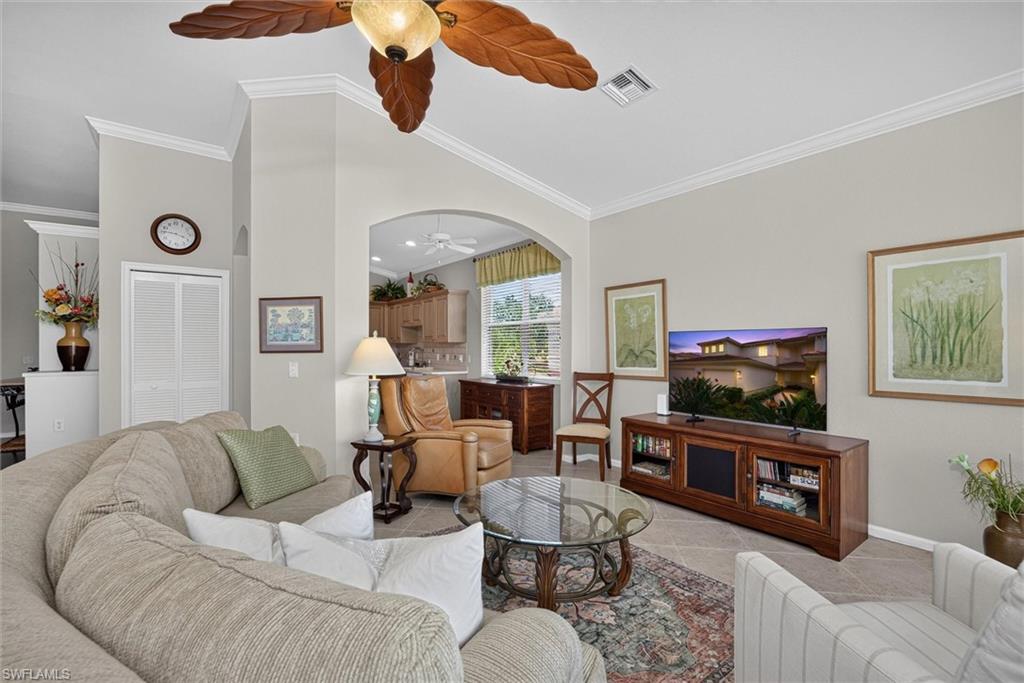 Spacious living area featuring neutral wall tones and crown molding