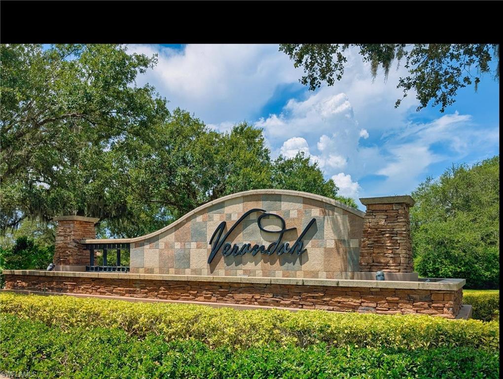 Monument signage featuring stone veneer columns and a curved wall with varied-tone rectangular tiles