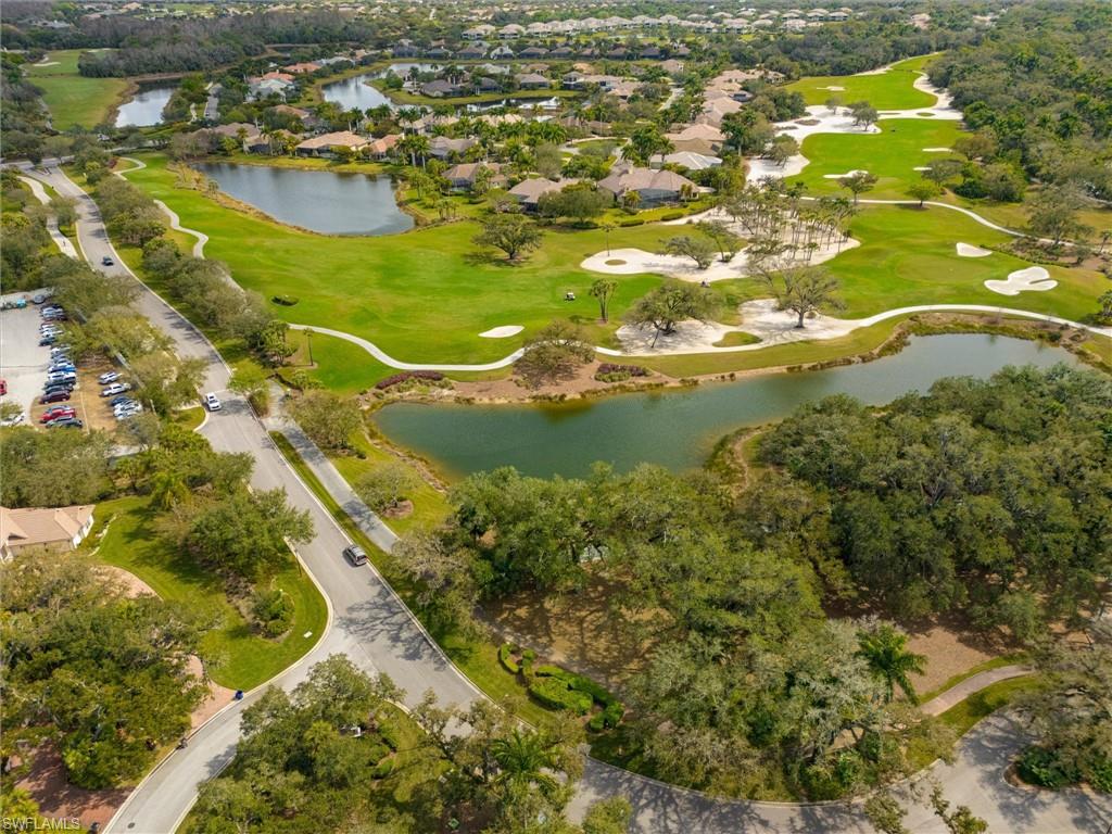 Aerial perspective showcasing a residential community with winding roads, multiple water features, and a golf course