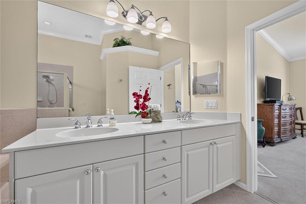 Dual vanity featuring white cabinetry with silver hardware, white countertops, and undermount sinks