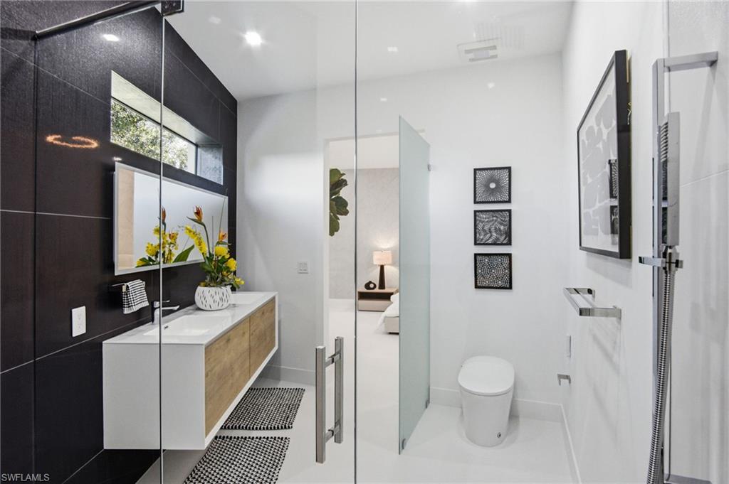 Bathroom featuring a floating vanity with wood-finish drawers, under-mount sink, and a large horizontal mirror