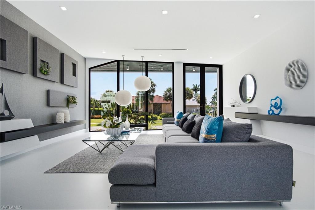 Expansive living area with large format flooring, recessed lighting, and floor-to-ceiling windows