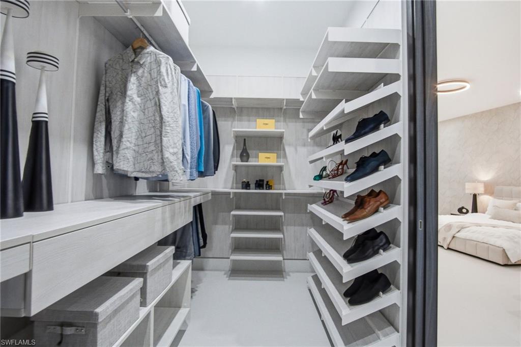 Custom closet system featuring light wood-finish cabinetry, integrated shelving, hanging rods, and an organized shoe display