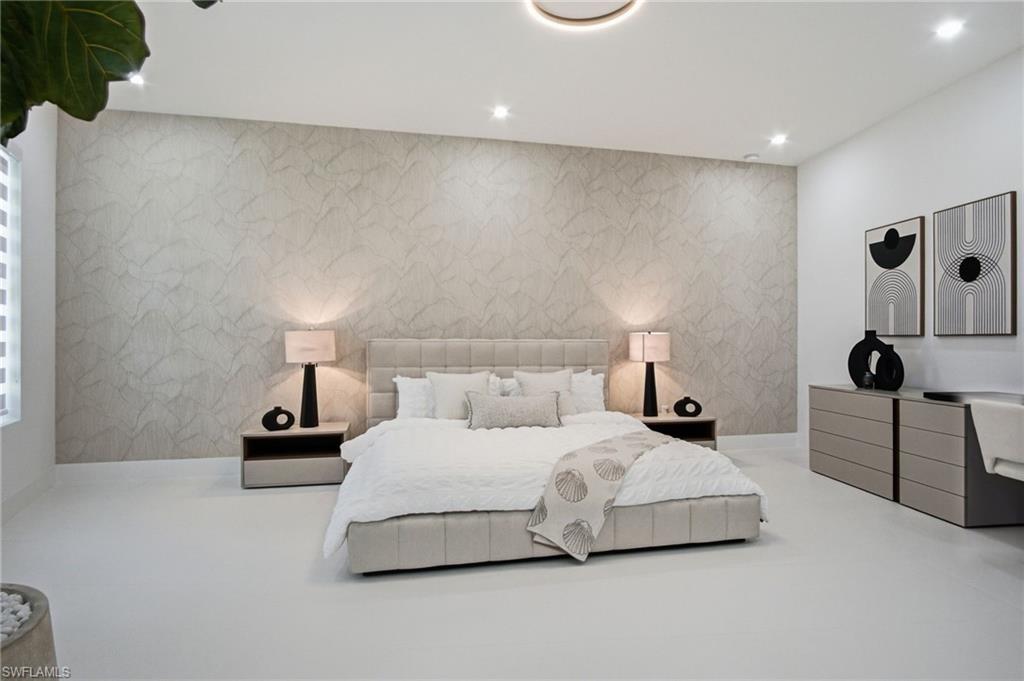 Spacious room featuring a textured accent wall, recessed lighting, and light-toned flooring