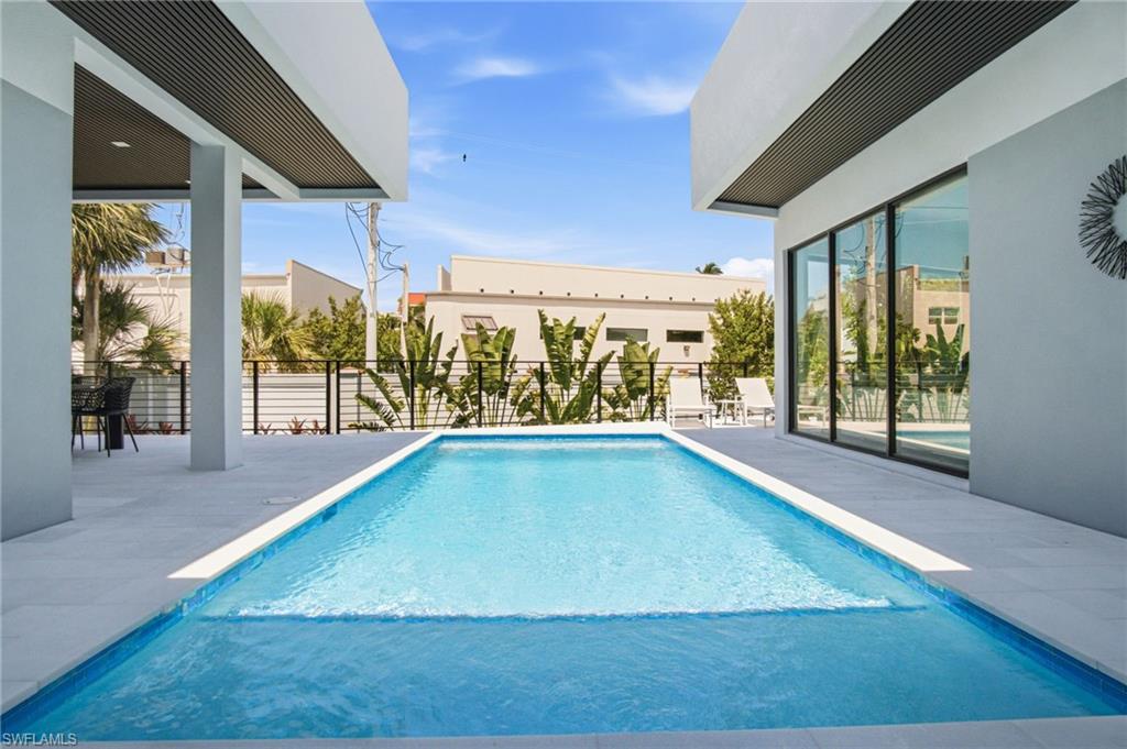 Rectangular pool with light blue tiling and white coping