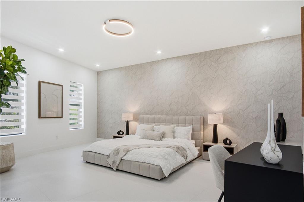 Spacious room featuring a textured accent wall, light-toned flooring, and recessed ceiling lights