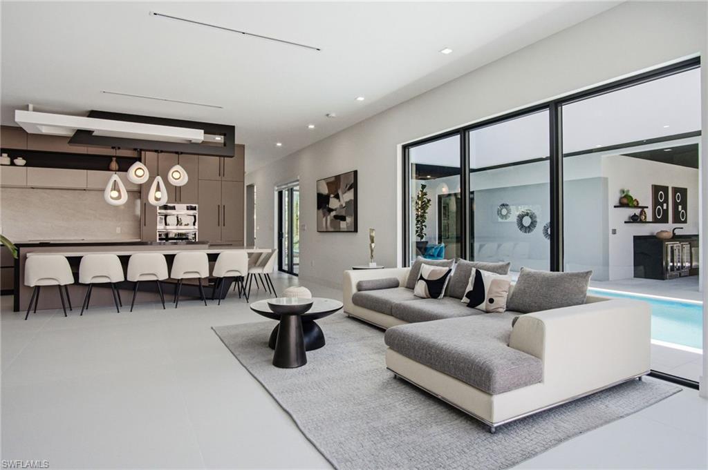 Open-concept living space with light-toned flooring and contemporary recessed lighting