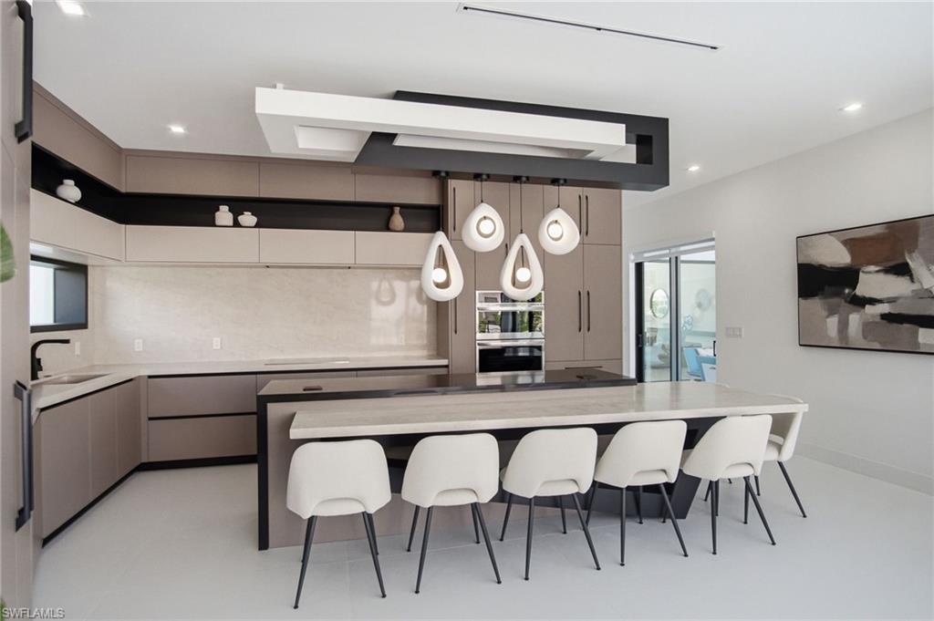 Contemporary kitchen featuring an expansive central island with seating