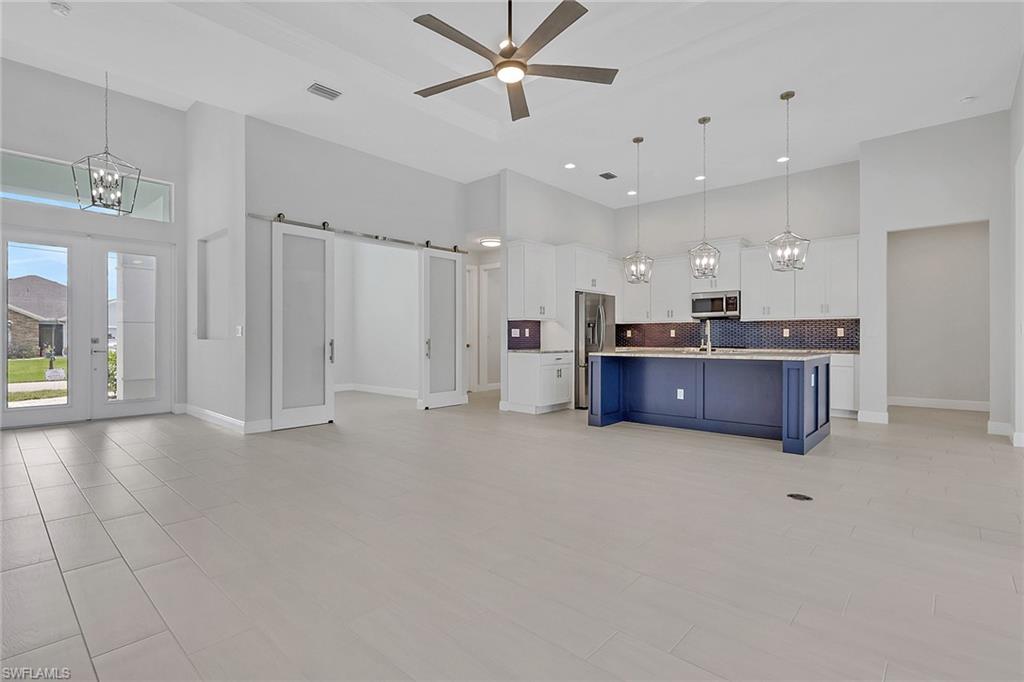 Great room and Island kitchen with granite counters, classic white shaker style cabinets with crown molding and crown molding.