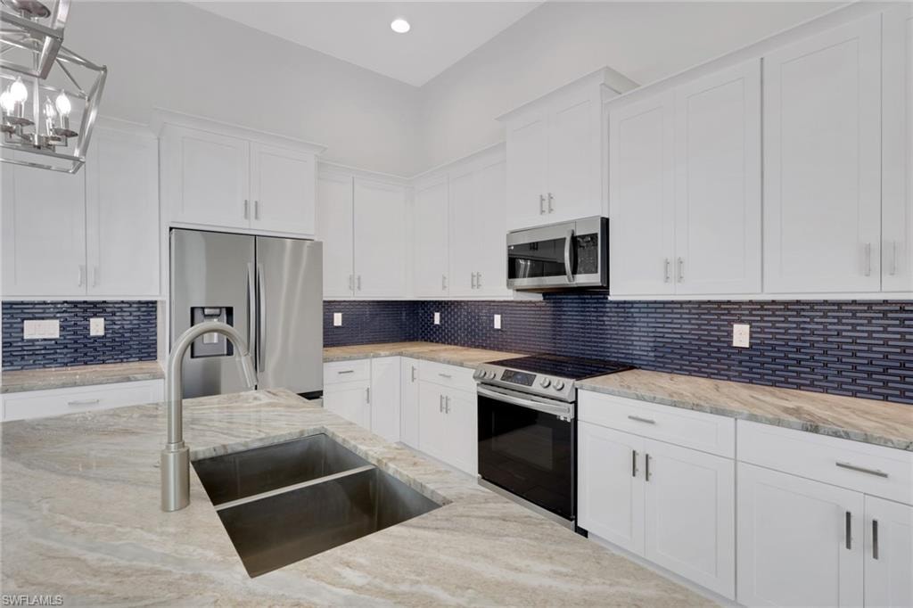 Island kitchen with granite counters, classic white shaker style cabinets with crown molding and crown molding, custom blue backsplash matched the blue island.