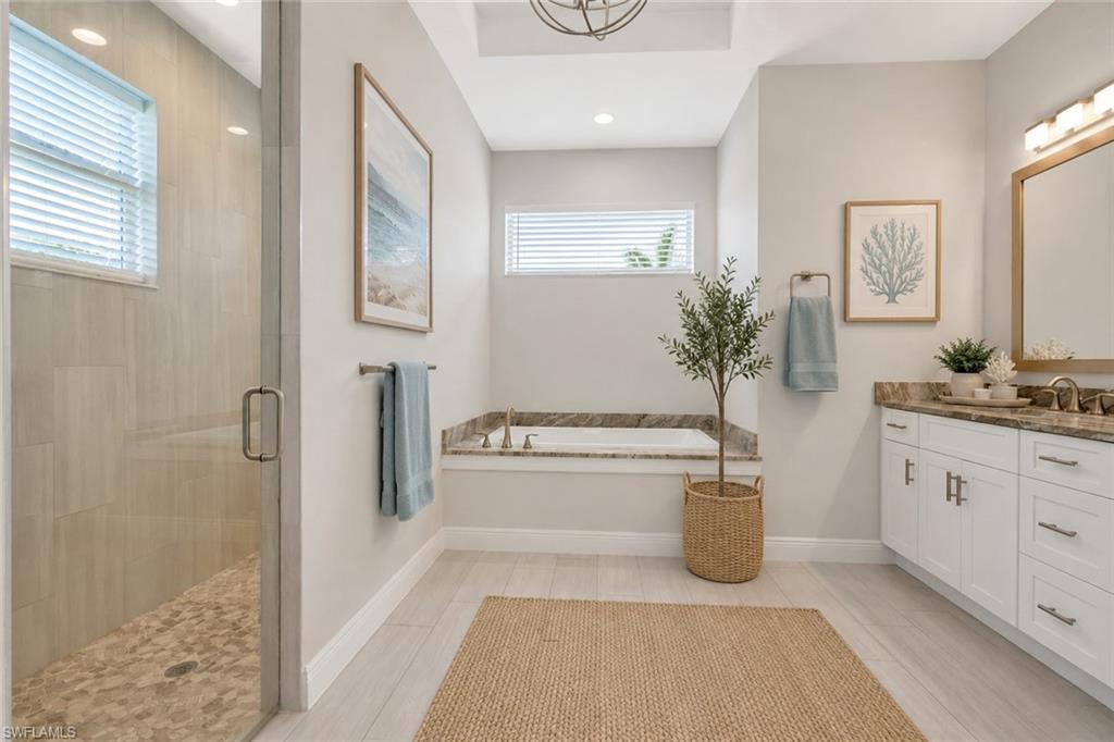 Owner's bath with dual vanities, matching granite counters, soaking tub and walk in shower, virtually staged