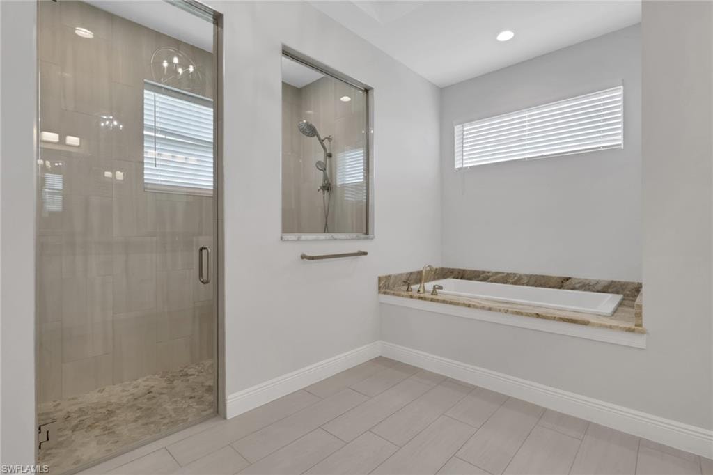 Owner's bath with dual vanities, matching granite counters, soaking tub and walk in shower
