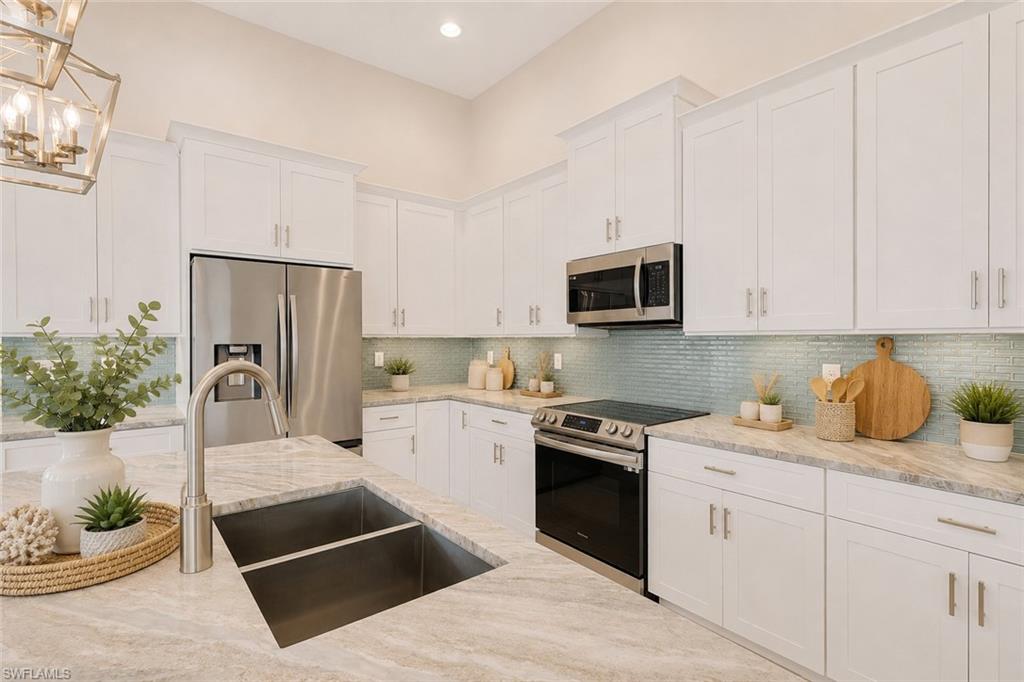 Island kitchen with granite counters, classic white shaker style cabinets with crown molding and crown molding. Virtually staged.