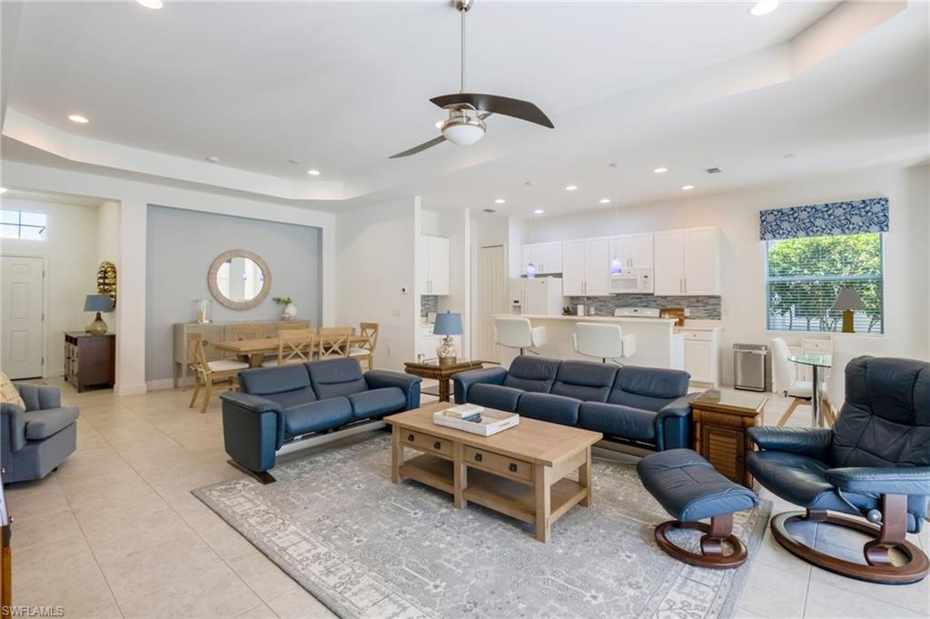 Open concept living area with tray ceiling and recessed lighting