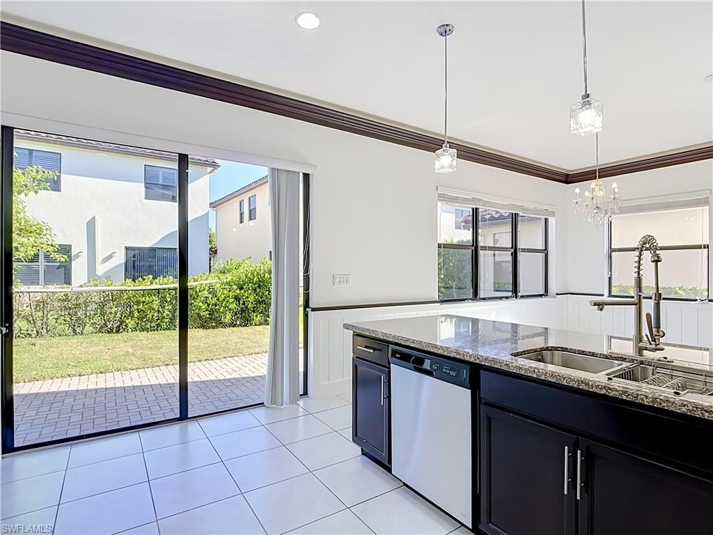 Kitchen island with granite countertop, integrated sink, and stainless steel dishwasher