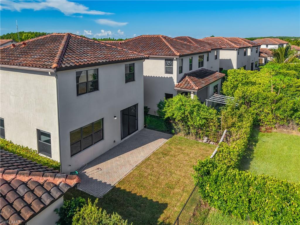 Rear exterior featuring a paver patio and expansive green space