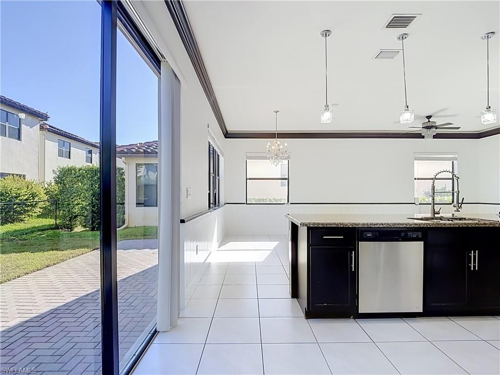 Spacious kitchen featuring an island with a dark countertop and stainless steel dishwasher, white tile flooring, recessed lighting, and a ceiling fan