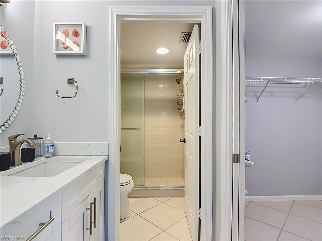 Bathroom vanity featuring a single basin, brushed nickel faucet, and white countertop