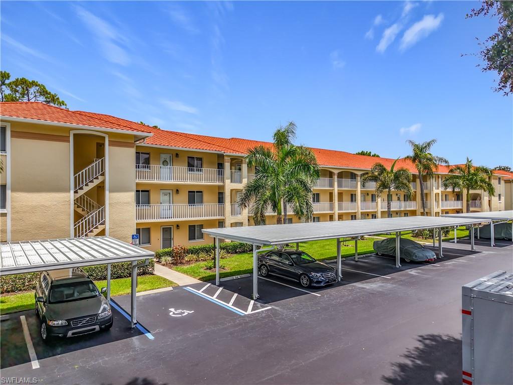 Multi-story residential building featuring a terracotta tile roof and light-colored stucco exterior