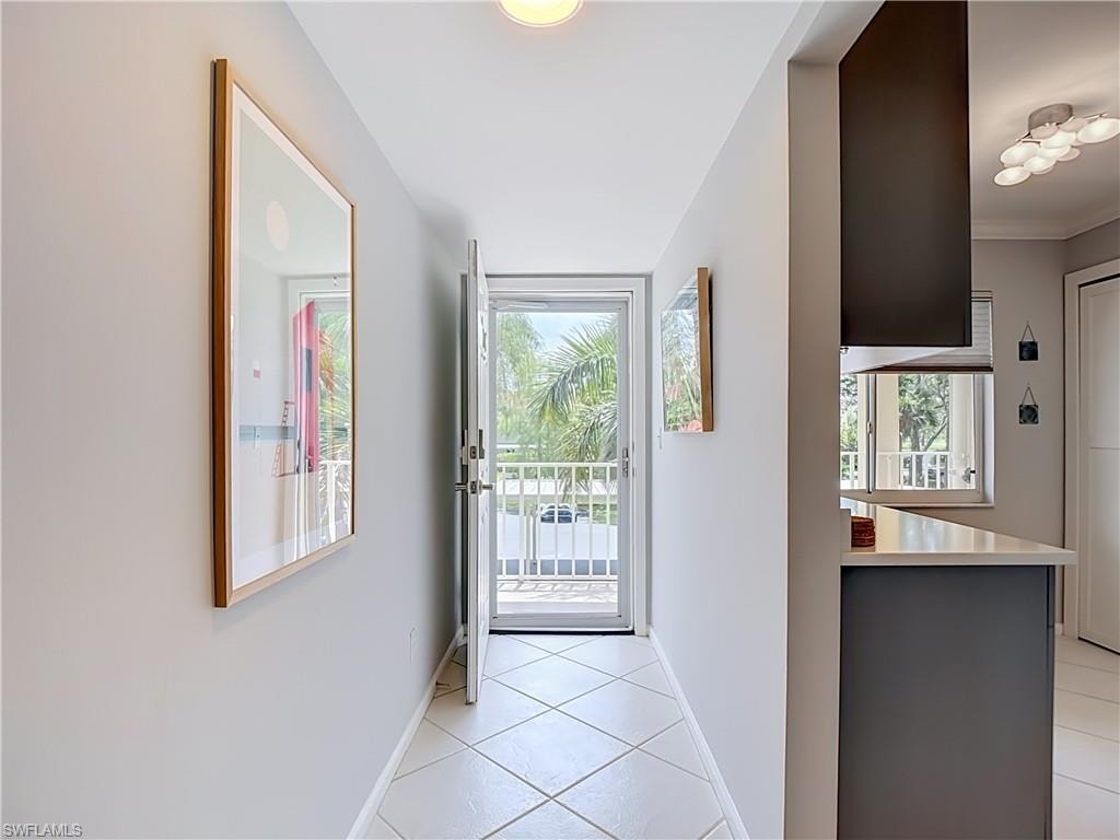 Bright entryway featuring diagonal tile flooring and a doorway opening to a white railing