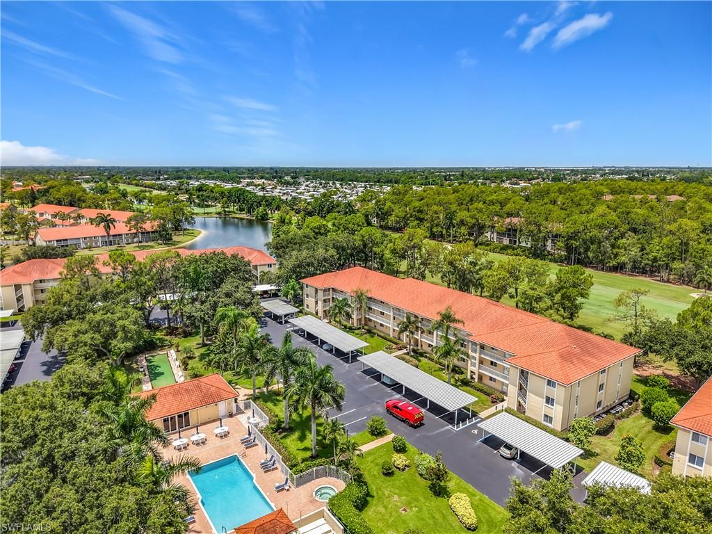 Community amenities featuring a swimming pool, hot tub, and shaded seating area