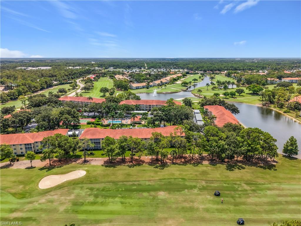 Expansive golf course property featuring multiple water features, mature trees, and red tile roof structures