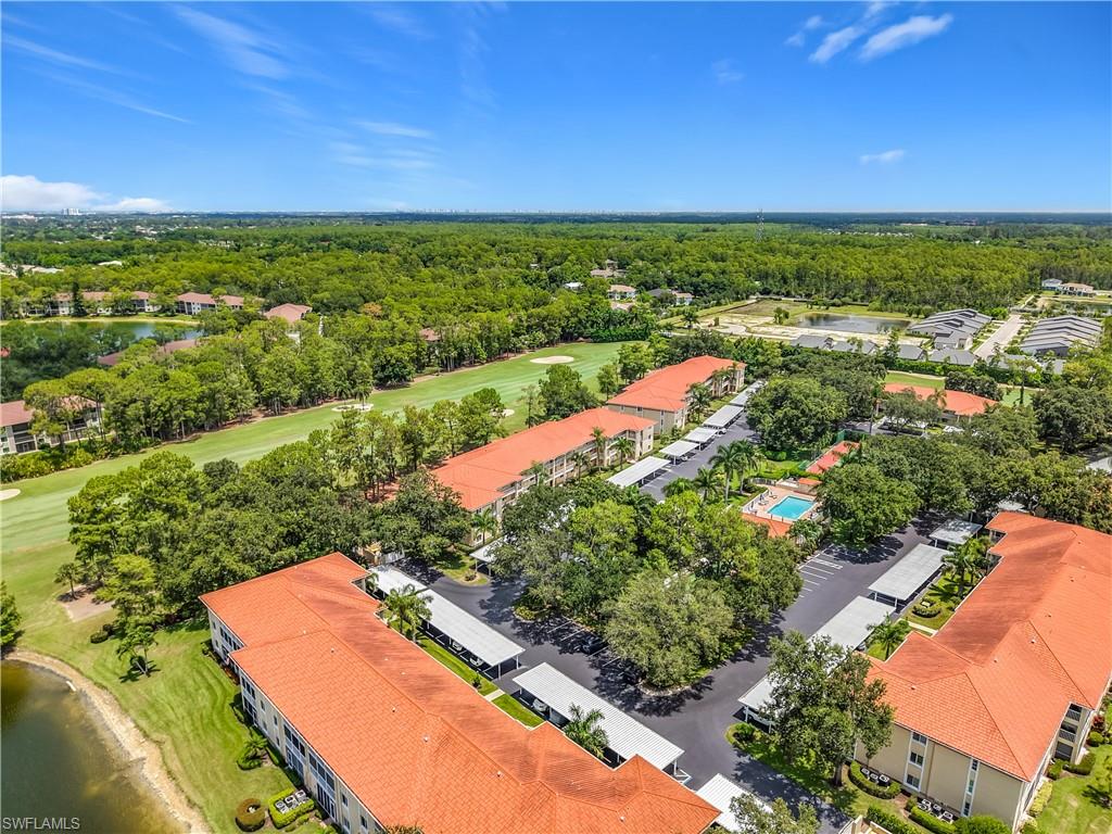 Aerial perspective featuring multiple low-rise structures with tile roofs, surrounded by dense greenery