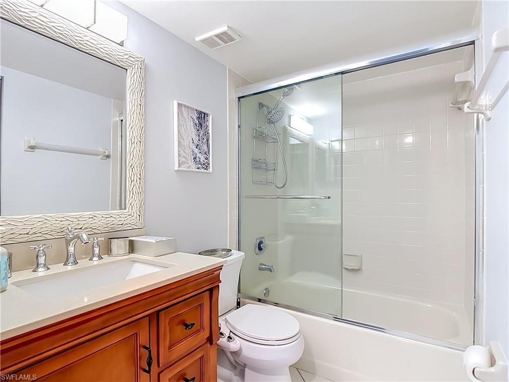 Full bathroom featuring a wood-finish vanity with an integrated sink, polished chrome faucet, and a light-colored countertop