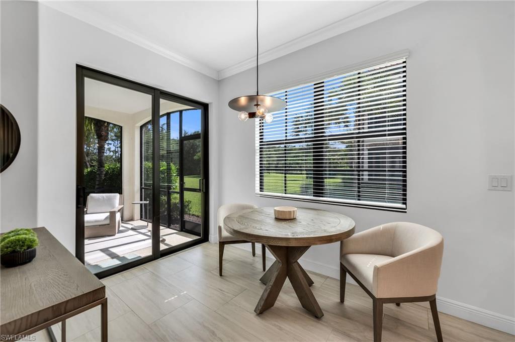 Spacious room featuring wood-finish flooring, a large window with horizontal blinds, and crown molding