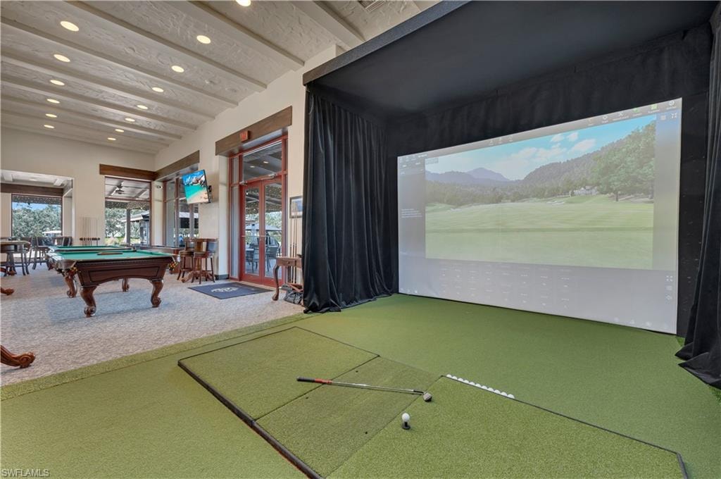 Indoor golf simulator with a large projection screen and artificial turf