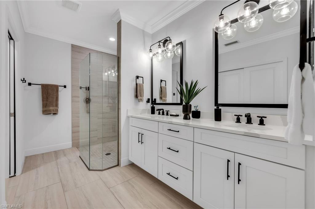 Double vanity featuring white cabinetry, black hardware, quartz countertops, and dual undermount sinks
