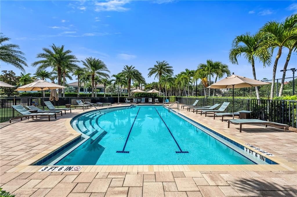 Resort-style swimming pool featuring a curved entry, lap lanes, and surrounding paved deck