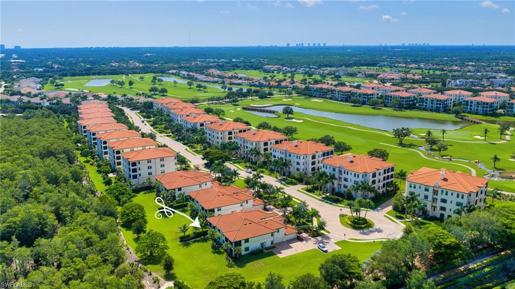 Aerial perspective of a multi-building residential community featuring red tile roofs and white exteriors