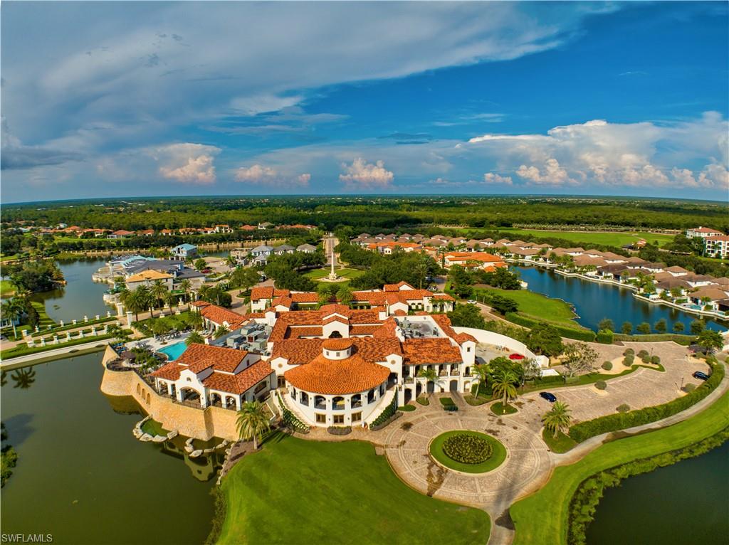 Expansive property featuring a Mediterranean-inspired main building with terracotta tile roofs, a circular drive, and an outdoor pool area