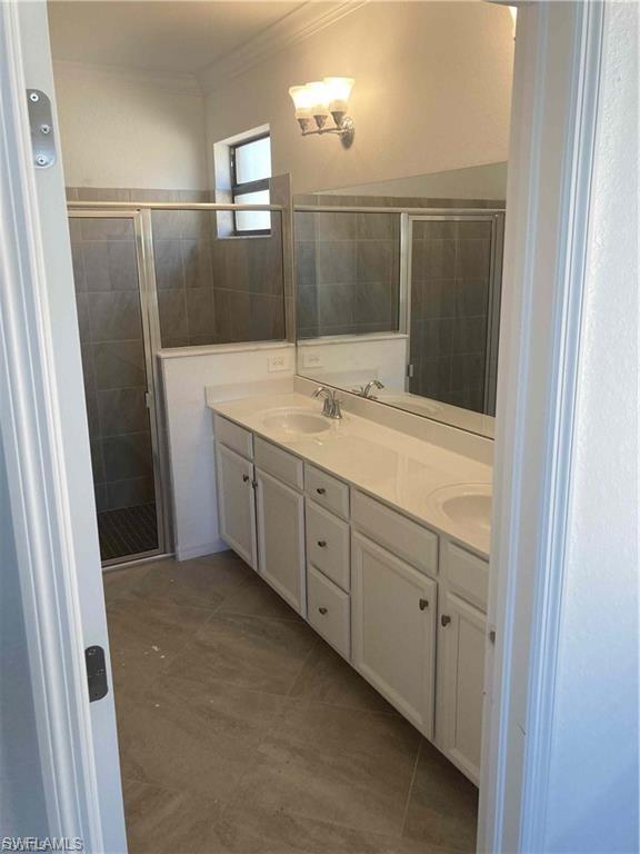 Bathroom featuring a dual vanity with white cabinetry, light-toned countertop, and undermount sinks
