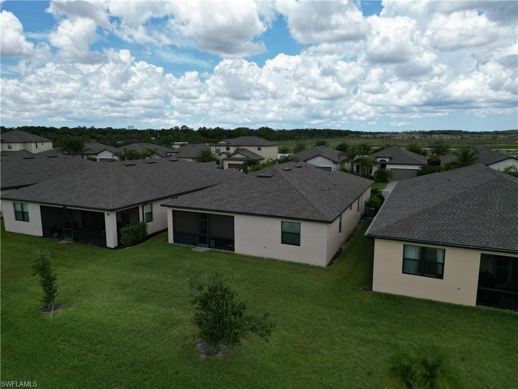 Residential neighborhood featuring a series of single-story homes with neutral stucco exteriors and dark shingle roofs