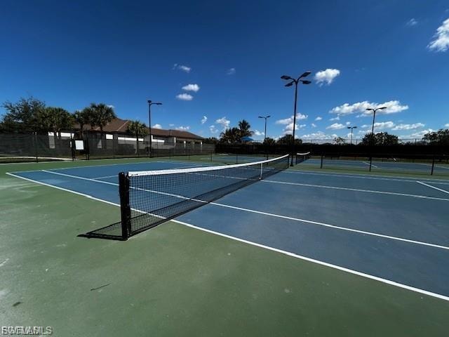 Outdoor tennis courts featuring a blue and green playing surface, white court lines, and black netting