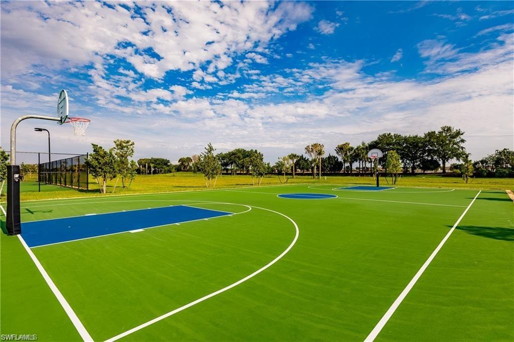 Multi-court athletic facility featuring bright green and blue playing surfaces, multiple basketball hoops, and perimeter fencing
