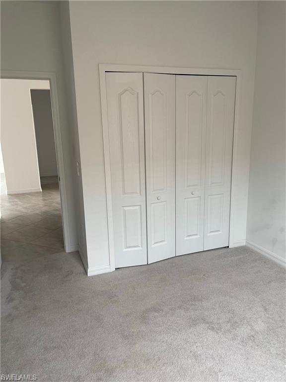 White bi-fold closet doors with raised panel details, set against light-colored walls