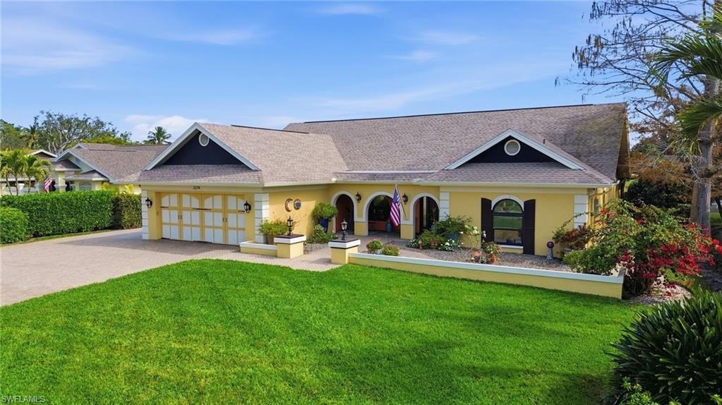 Front exterior with extended paver driveway offering ample parking and easy access entry