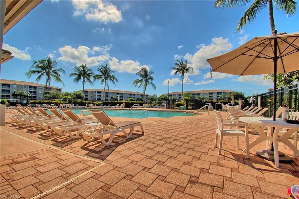 Expansive paved pool deck featuring a geometric swimming pool