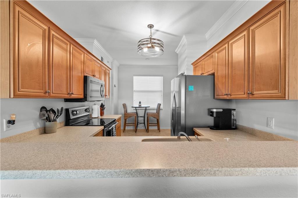 Kitchen featuring Maple cabinets, Corian Counters, newer stainless appliances, updated lighting.