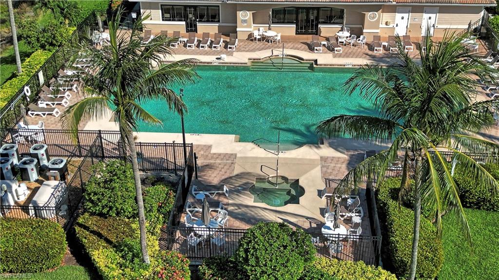 Expansive communal pool area featuring a large swimming pool, integrated spa, and surrounding lounge seating
