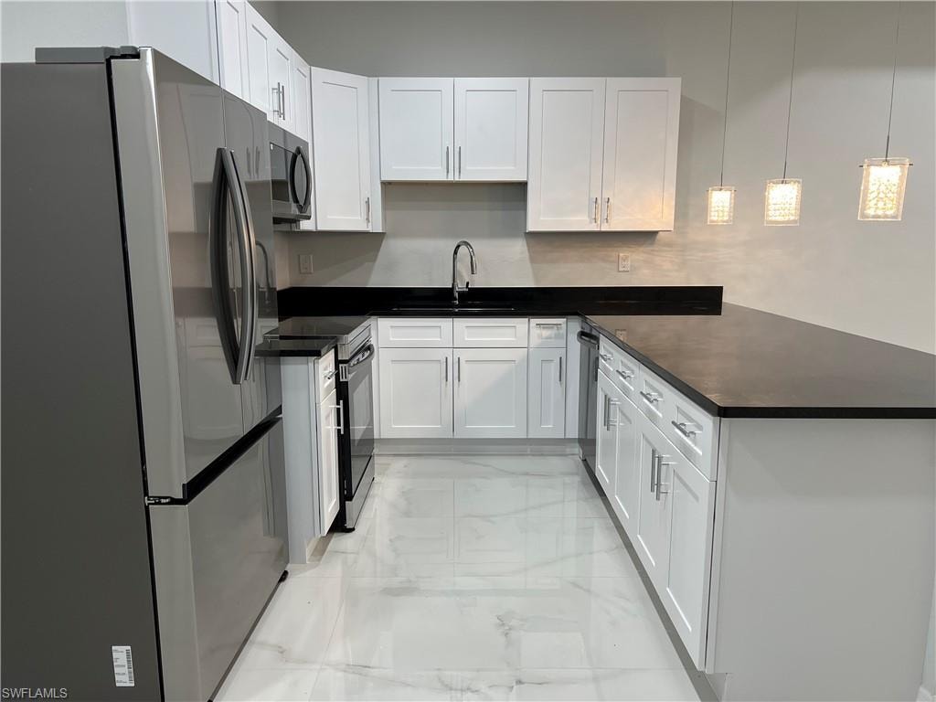 Kitchen featuring white shaker cabinetry, stainless steel appliances, dark countertops, and white tile flooring