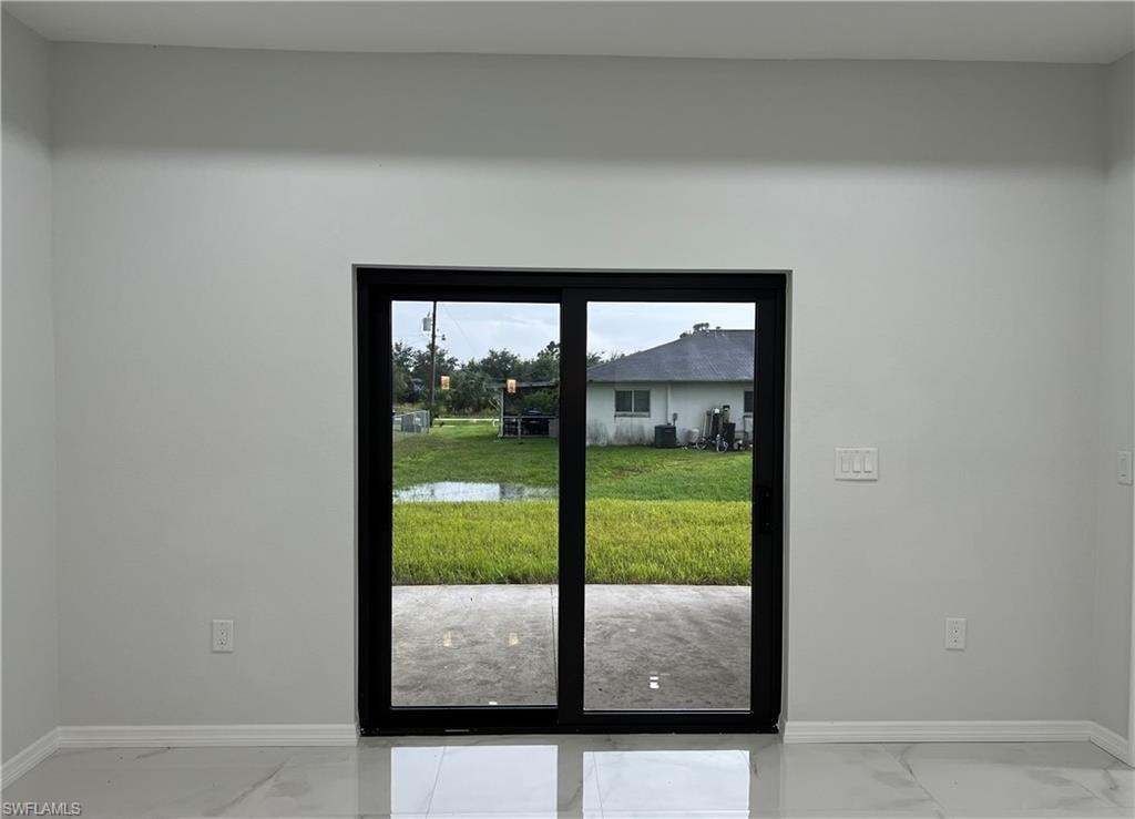 Sliding glass door opening to a concrete patio and green space