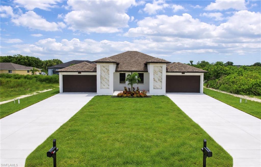 Contemporary duplex featuring a stucco exterior with decorative stone accents, dual two-car garages, and separate concrete driveways