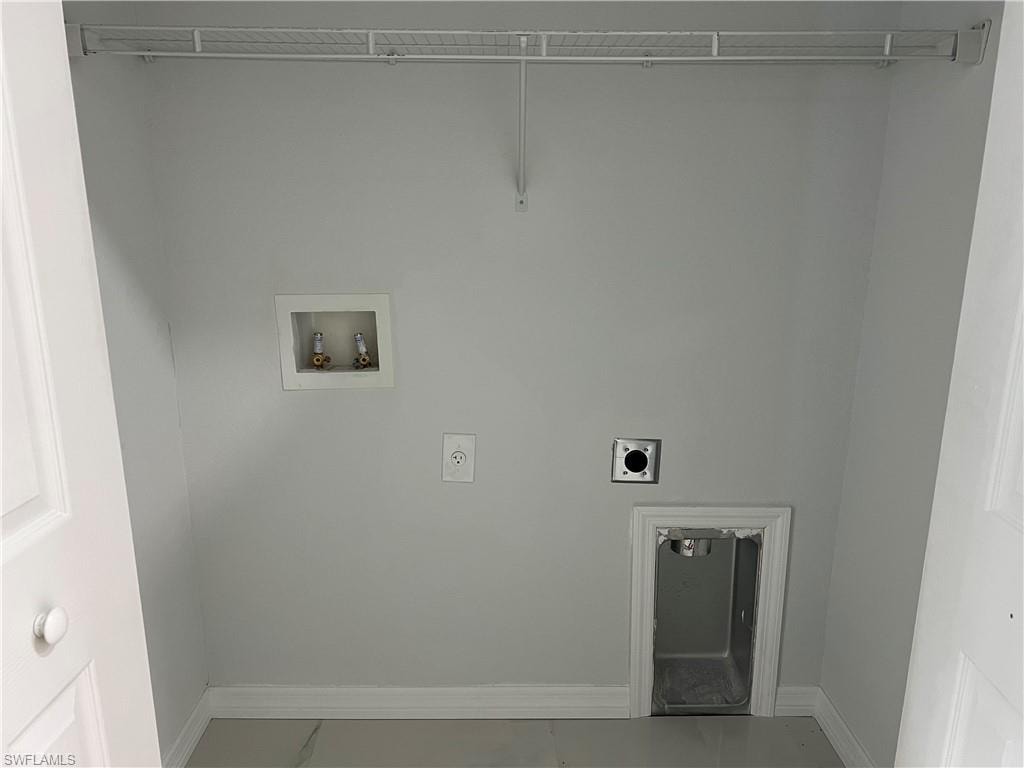 Dedicated utility area featuring a wire shelf, washer hookup, dryer vent, and a utility sink basin