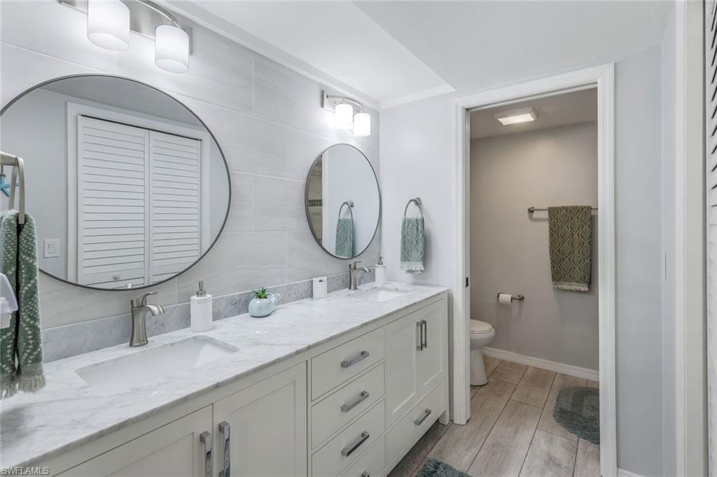 Double vanity with a marble-finish countertop, undermount sinks, and brushed nickel faucets