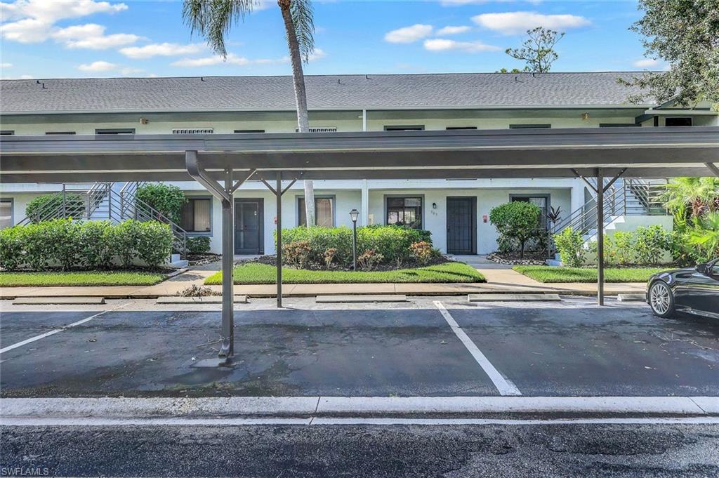 Covered parking space with a multifamily building backdrop